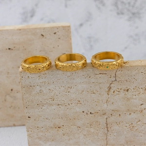Macro shot of gold vintage rings featuring relief sun, moon and star motifs with zircons