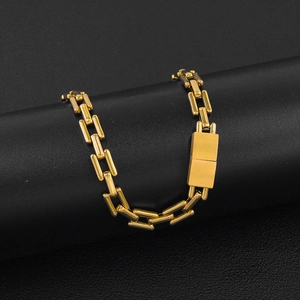 Detail of gold rectangular link chain showing polished mirror finish and wide clasp