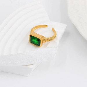 Detailed view of adjustable golden twisted ring with emerald cut green zircon stone