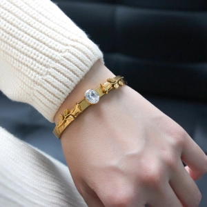 Detail of 18K gold-plated stainless steel rose bracelet with inlaid oval crystal