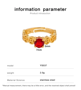 Detail view of gold stainless steel ring with red zircon and hollow coin pattern design