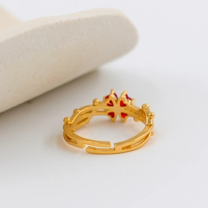 Adjustable gold plated ring with red heart-shaped stones in a four-leaf clover design
