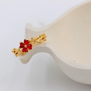 Golden branch ring with red heart-shaped zircon stones in a lucky clover design