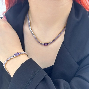 Détail d'un ensemble collier et bracelet en or avec zircons violets sur un mannequin