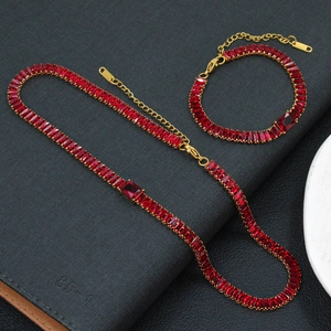 Vue macro d'un ensemble collier et bracelet en plaqué or avec zircons rouges et fermoir