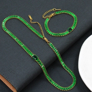 Vue détaillée de la parure de bijoux dorée avec des pierres de zircon vert émeraude