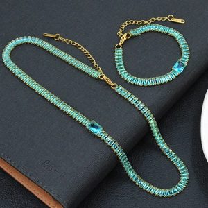 Détail macro de l'ensemble collier et bracelet dorés avec zircons carrés bleu clair