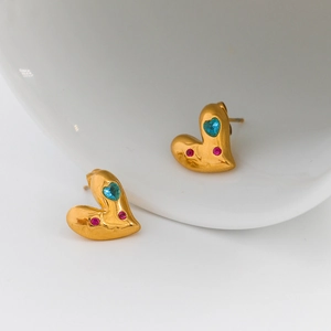 Detalle de pendientes de corazón vintage con piedras azules y rosas en acero inoxidable