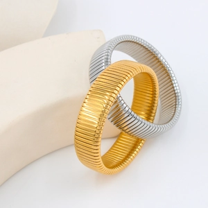 Dettaglio di bracciali Tubogas in oro e argento intrecciati su un espositore curvo