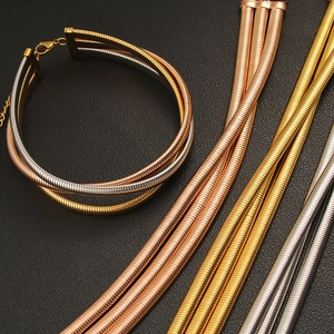 Detailed view of layered snake chains in silver, gold, and rose gold with lobster clasp