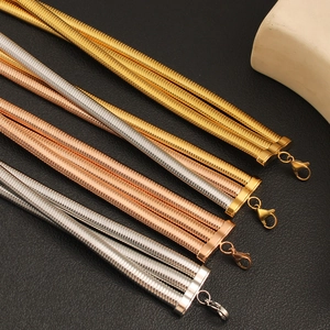 Detail view of triple-layered snake chain necklaces in gold, silver, and rose gold finishes