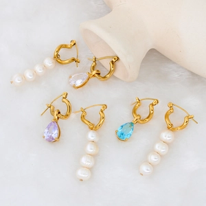 Detail of gold drop earrings with tiered white pearls and colorful teardrop zircon stones