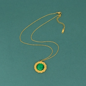 Detail of gold titanium steel necklace with green turquoise stone pendant for women