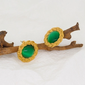Close-up of vintage gold stud earrings with oval green stone and twisted rope texture