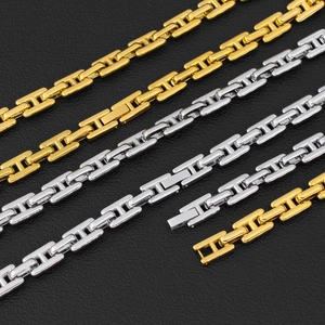 Primer plano de cadenas gruesas con eslabones en H pulidos en oro y plata sobre cuero