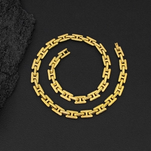 Detalle de la cadena de eslabones H en acero de titanio dorado pulido sobre cuero