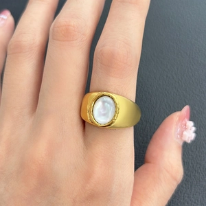 Gros plan d'une bague de fiançailles plaquée or 18K avec pierre ovale portée