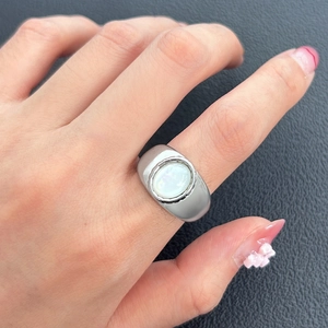 Détail d'une bague vintage en argent avec pierre ovale crème sur cuir texturé foncé