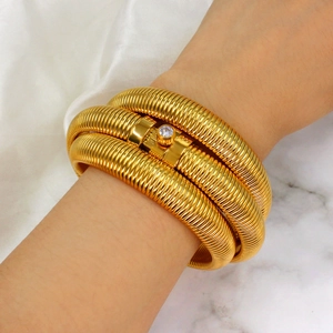 Elegant gold spiral layered cuff bracelet with a sparkling center zircon stone for women