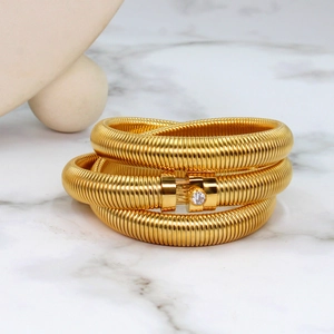 Detailed macro view of gold Tubogas spiral bracelet with a sparkling zircon clasp detail