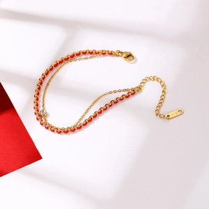Gros plan d'un bracelet en corde rouge et acier titane avec poinçon K18 et zircone