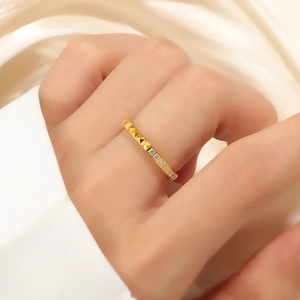 Eleganter Ring aus goldenem Titanstahl mit Pavé-Diamanten und facettiertem Nietendesign