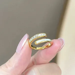 Détail d'une bague dorée ajustable avec oxydes de zirconium et incrustation de nacre
