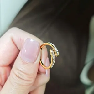 Gros plan détaillé d'une bague dorée ajustable avec zircons scintillants et nacre blanche