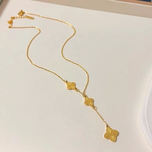 Luxurious 18K gold plated titanium necklace with triple clover fringe tassels on display
