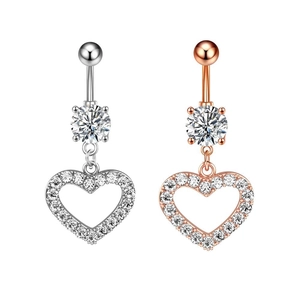 Dettaglio di piercing all'ombelico in argento e oro rosa con ciondoli a cuore in zirconia