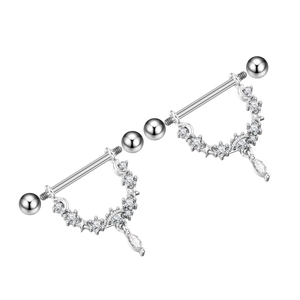 Macro detail van tepelpiercing set met sterren, maan en sprankelende zirkoniasteen