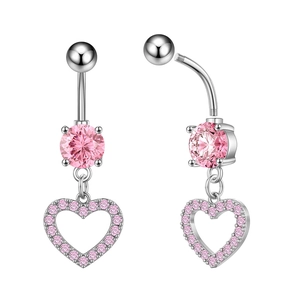 Dettaglio macro del piercing all'ombelico con cuore rosa in zircone e acciaio lucido