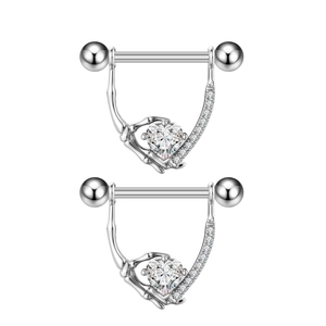Detail van de skelethand tepelpiercings met hartvormige steen en zirkonia pavé