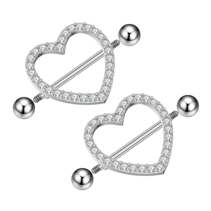 Macro detail of heart-shaped nipple rings with sparkling cubic zirconia on silver steel