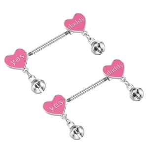 Macro detail of heart-shaped nipple barbells with yes daddy text and pink enamel charms