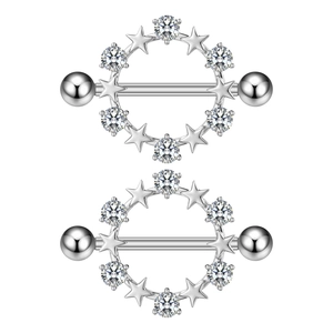 Macro shot of silver heart-shaped nipple rings with sparkling zircon stars and steel barbells