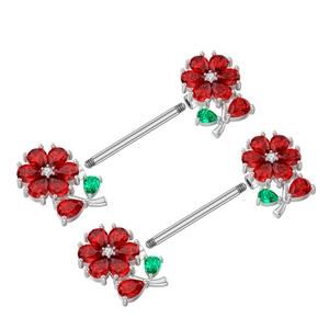 Detail von blumenförmigen Nippelringen mit roten und grünen Zirkonia auf Silberhantel