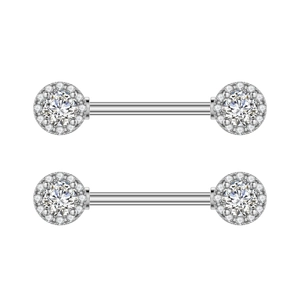 Primer plano de piercings de pezón tipo barra plateada con halos de circón brillante