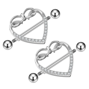 Macro shot of silver heart nipple rings with zircon stones and bow detail on white backdrop