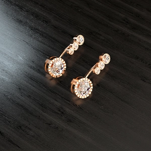 Rose gold navel ring with four round cubic zirconia in a curved stainless steel setting