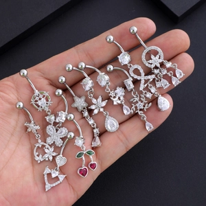 Dettaglio di vari piercing all'ombelico in acciaio inossidabile con ciondoli a cuore