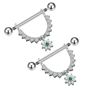 Detail of silver nipple rings featuring green flower pendants and sparkling zircon stones