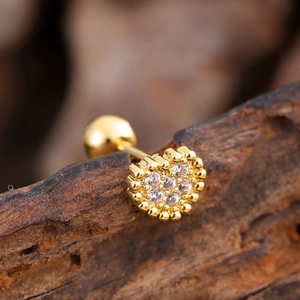 Macro detail of heart-shaped gold stud earring with zircons and screw ball back