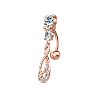 Gros plan sur un piercing de nombril en or rose avec pendentif goutte en zircon