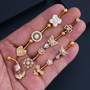Detailed view of gold-plated belly rings and industrial bars with butterfly and heart zircon