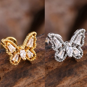 Macro shot of gold and silver butterfly stud earrings with sparkling cubic zirconia inlay