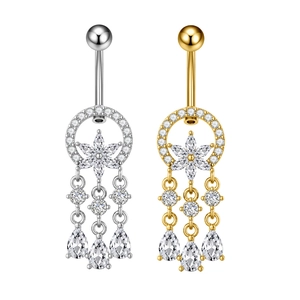 Dettaglio di piercing all'ombelico in oro e argento con fiori di zircone e nappine