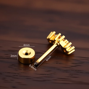 Macro view of gold piercing stud with 0.8x6x4mm size specifications on wood