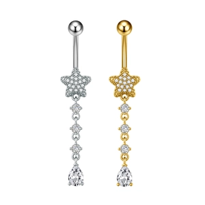 Dettaglio di piercing all'ombelico in oro e argento con stelle e nappine in zirconia
