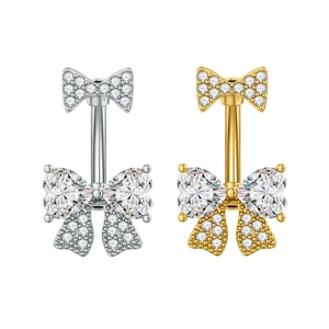 Nahaufnahme von bogenförmigen Bauchnabelpiercings in Silber und Gold mit Zirkon-Steinen